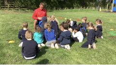 Man talking to a group of children outside