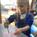 Girl mixing pink flour in a jug