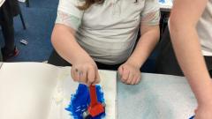 Pupil using a roller to print the ink