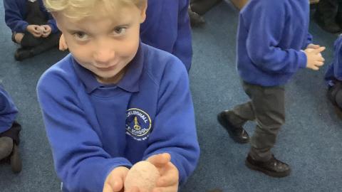 a boy holding a salt dough egg