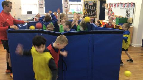 Children in their PE lesson taking part in a game called ‘popcorn’.