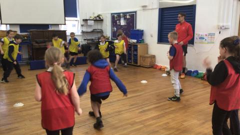 Children in their PE lesson taking part in a game called ‘popcorn’.