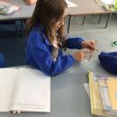 Martha experimenting with how a rubber band attached to a ruler vibrates