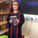 Willow class pupil dressed up as a wizard holding a Harry Potter book