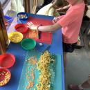 Children making seaside pictures using pasta and lentils