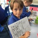 Child using a whiteboard to show their understanding of our maths 