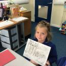 Child using a whiteboard to show their understanding of our maths 