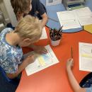 Children designing and writing postcards