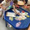 Children catching paper fish with words on