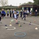 children taking it in turns to hit a beanbag into a hoop