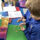 Children making a picture of a rocket with pasta and match sticks