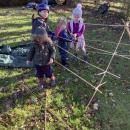 Children using sticks to build a den