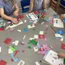 Children cutting and sticking coloured paper