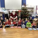 The children with Santa and their gifts 