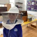 Pupils tries on the beekeeper veil
