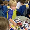 child printing on paper with conkers